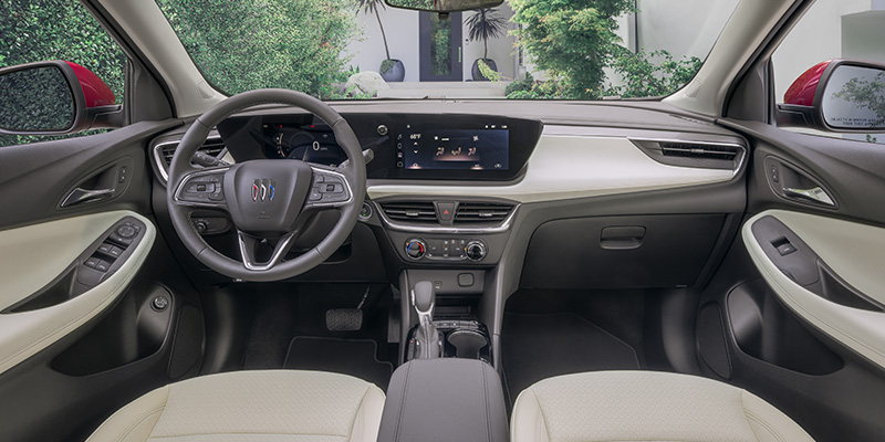 The modern interior of a Buick Encore-GX featuring a two-tone cream and black dashboard with a large integrated digital display.