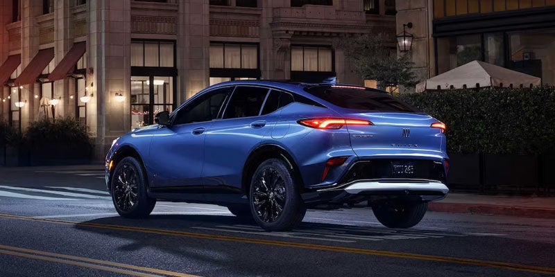 Blue 2026 Buick Envista driving in downtown area